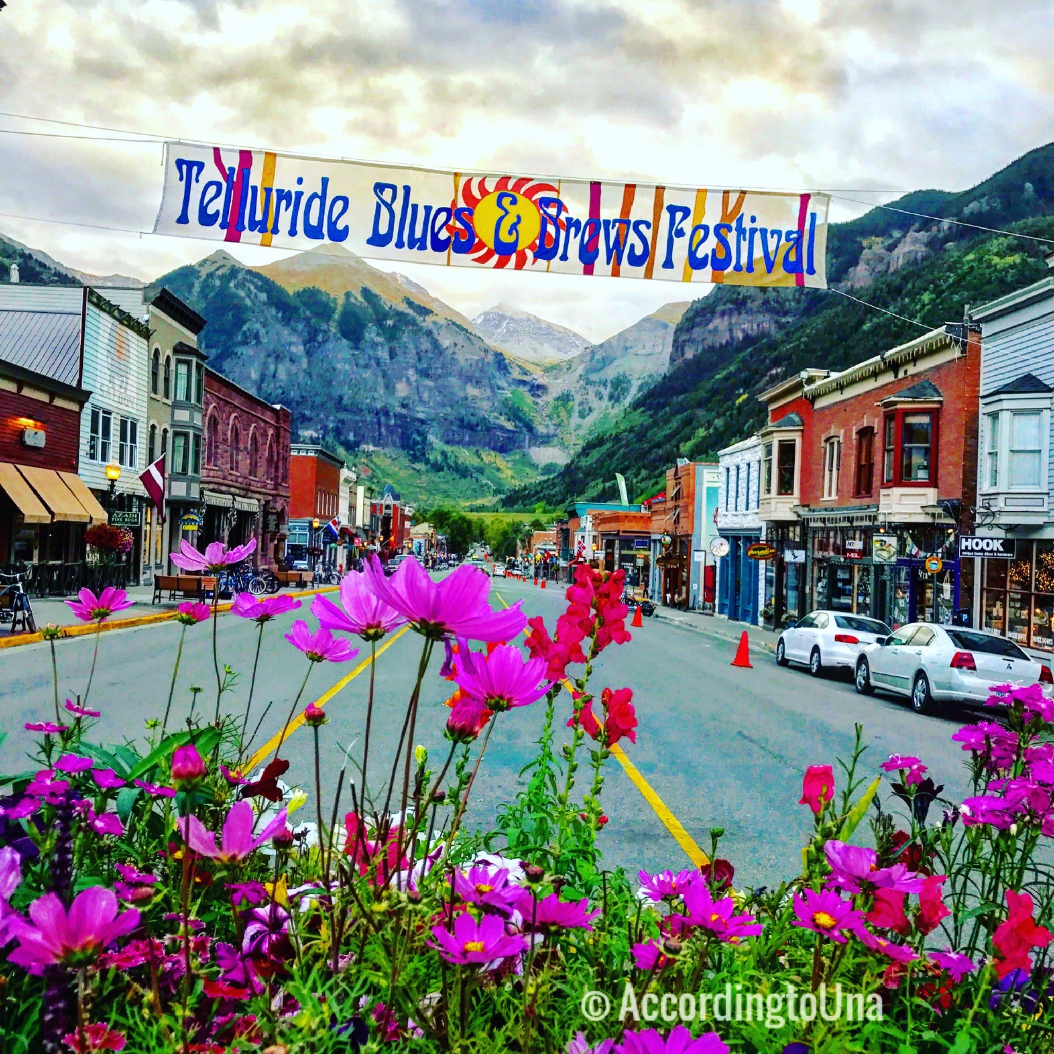 Telluride main street with flowers, storefronts, and mountain backdrop